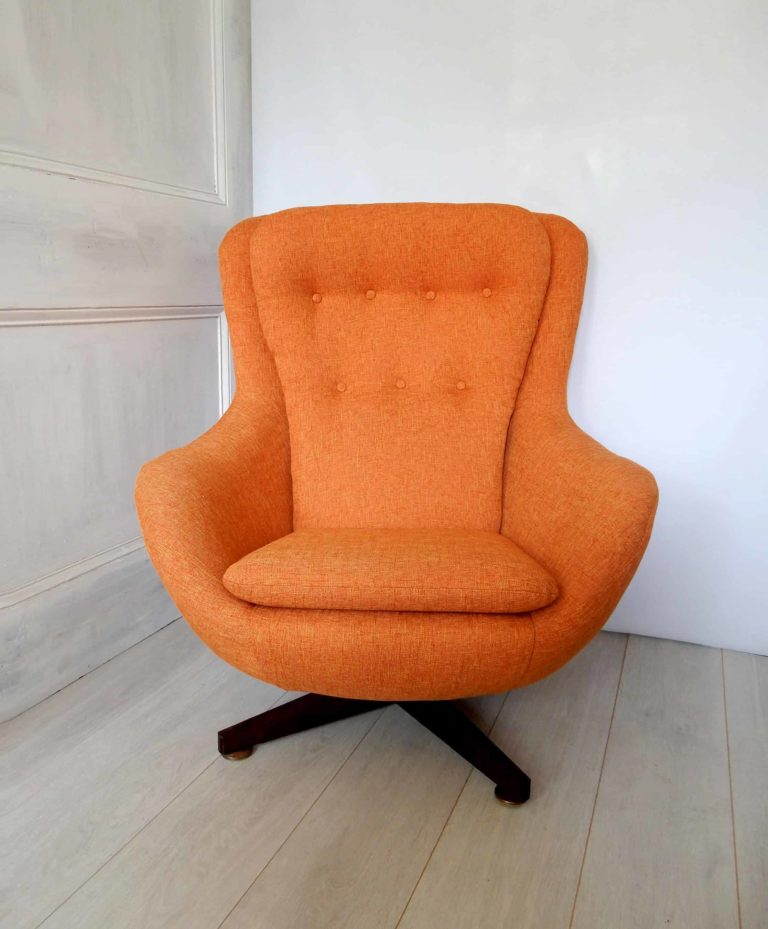 An orange 1970s retro swivel chair; newly upholstered.