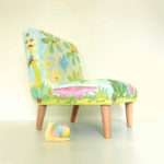 Little chair in a printed fabric of cute animals, bugs, birds, leaves, flowers in blues and greens.