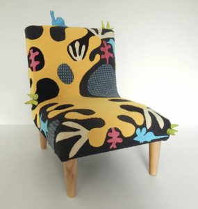 Child’s chair, handmade wool appliqué fabric decorated with abstract shapes and animals.