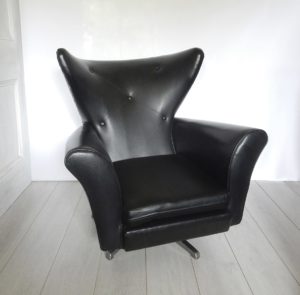 A vintage 1960s-70 swivel armchair in black vinyl fabric.