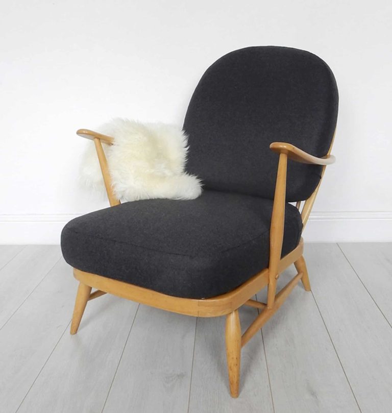 A classic Ercol 203 armchair: charcoal black wool cushions and sheepskin. Front view