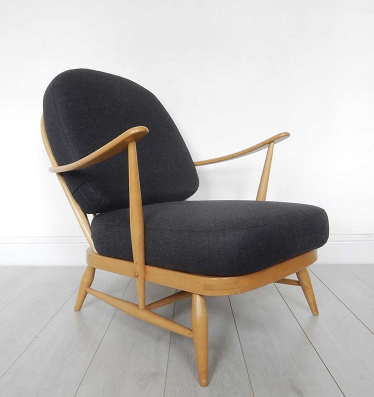 A classic Ercol 203 armchair: charcoal black wool cushions and sheepskin.