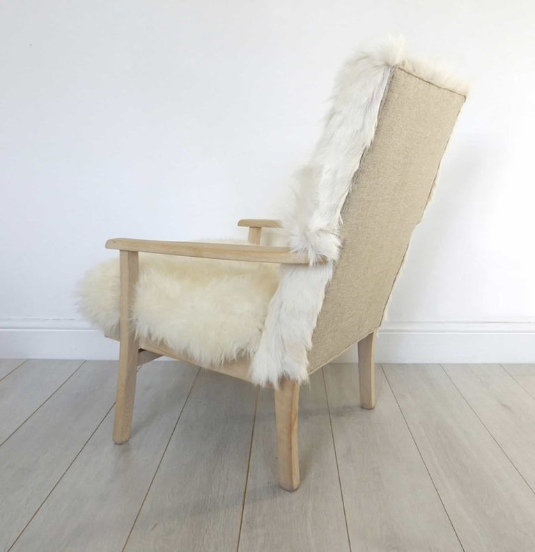 A vintage Parker Knoll armchair; sheepskin seat and goat hair on hide to back. Rear view.
