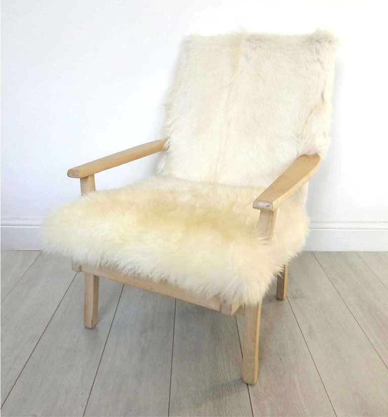 A vintage Parker Knoll armchair; sheepskin seat and goat hair on hide to back.