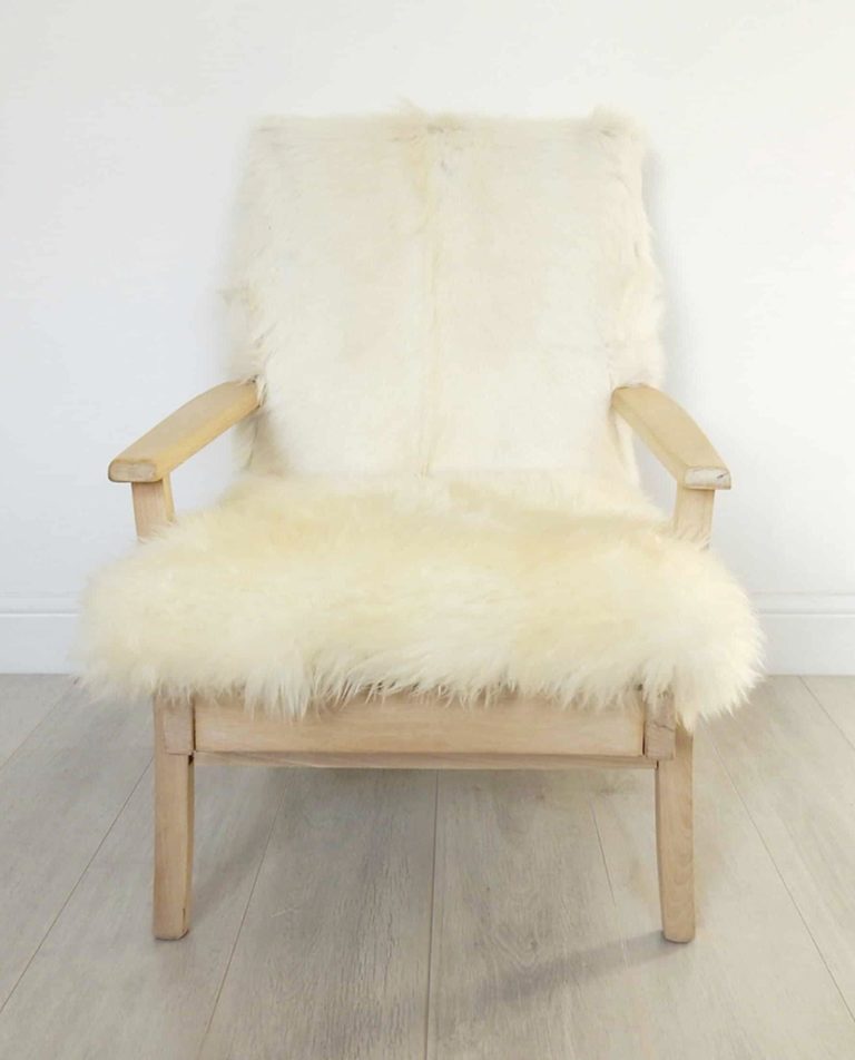 A vintage Parker Knoll armchair; sheepskin seat and goat hair on hide to back.