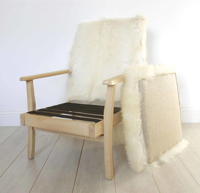 A vintage Parker Knoll armchair; sheepskin seat and goat hair on hide to back.