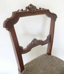 A traditionally upholstered walnut Victorian side chair; detail of show wood.